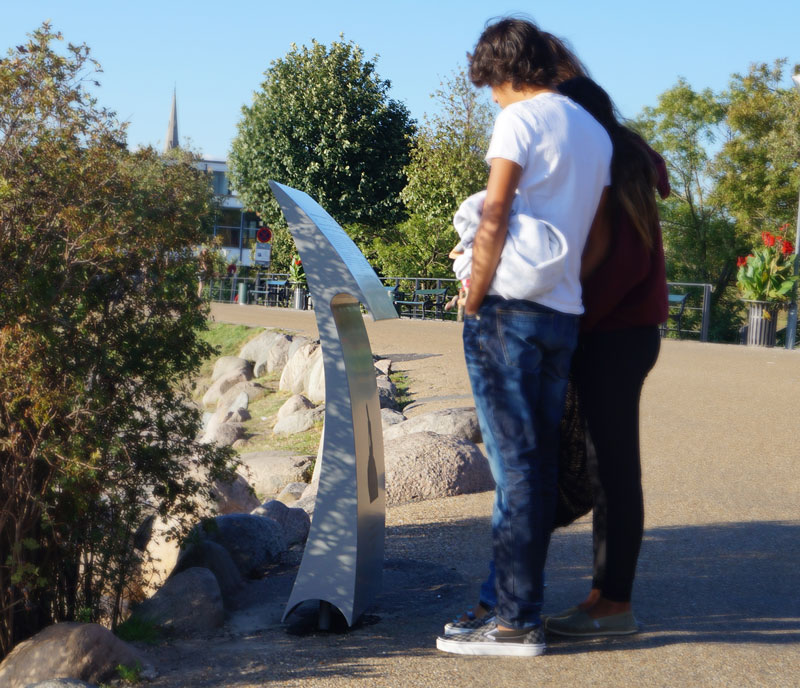 Turister kigger på havfrue skilt